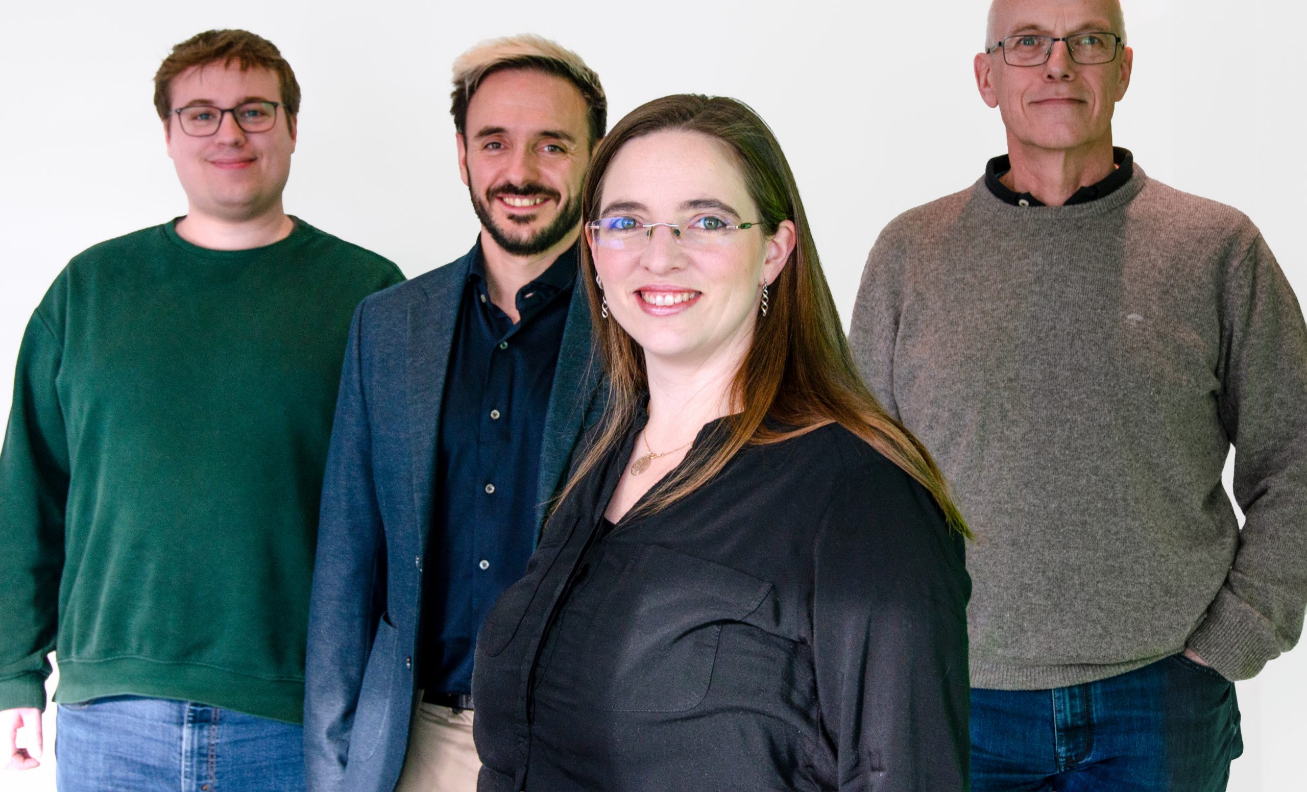 Team CAIGOS steht zusammen und schaut sympatisch in die Kamra